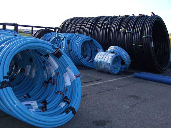 Blue-Pipe-Coils-in-Yard Coiled Water Distribution Pipe Coils